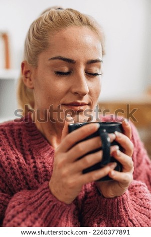 Blonde woman enjoying a hot drink