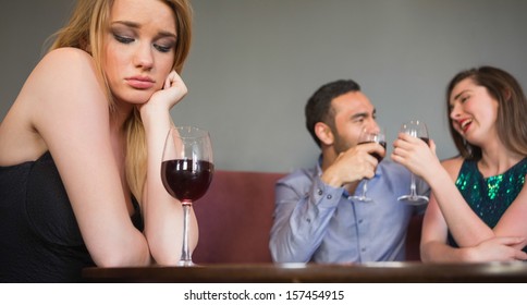 Blonde woman feeling envious of two people are flirting beside her in a nightclub - Powered by Shutterstock