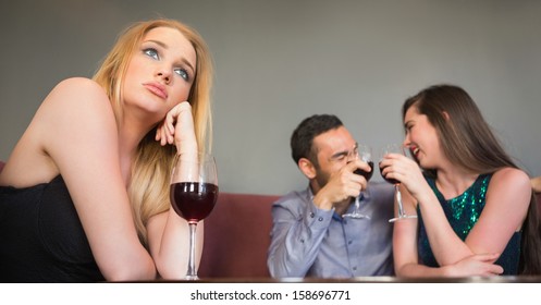 Blonde woman feeling jealous of two people are flirting beside her in a nightclub - Powered by Shutterstock