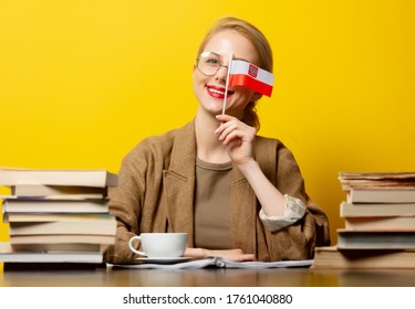 blonde woman with flag of Poland and books on yellow background