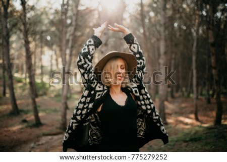 Similar – Blonde woman with hat taking a walk in the forest at sunset with the sun in the background.