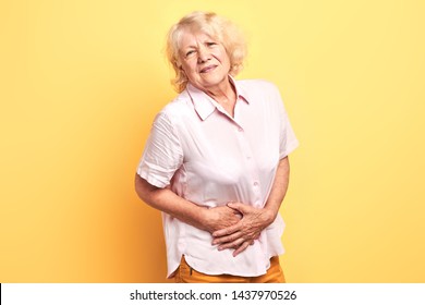 Blonde Woman Having Pain In The Liver. Syros Liver. Close Up. Isolated Yellow Background.illness Concept