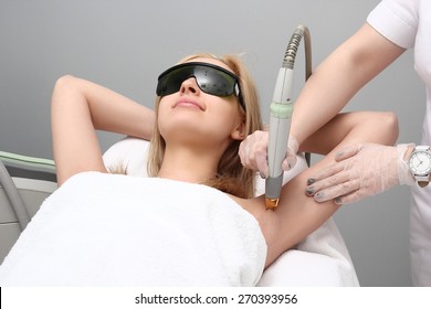 Blonde woman having underarm Laser hair removal epilation. Laser treatment in cosmetic salon - Shutterstock ID 270393956
