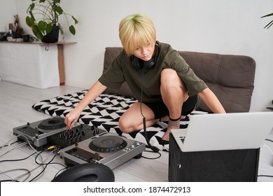 Blonde woman producing and mixing modern style beats music, beat making and arranging audio content with software controllers and digital effects processors. Recording electronic music track in home