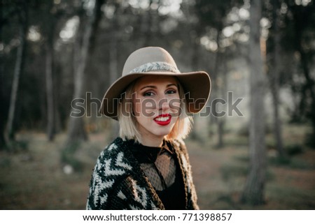 Image, Stock Photo Blonde woman with hat taking a walk in the forest at sunset with the sun in the background.