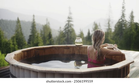 Blonde woman relaxes taking hot tube at mountain eco resort - Powered by Shutterstock