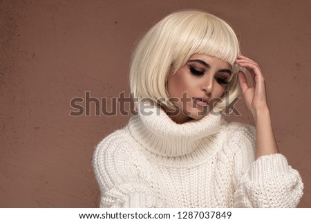 Blonde woman with short fashionable wig . Beautiful model girl. Care and beauty products.