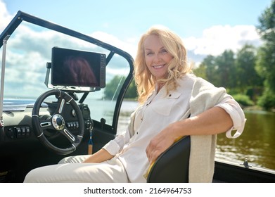 Blonde woman sitting in a boat and looking relaxed