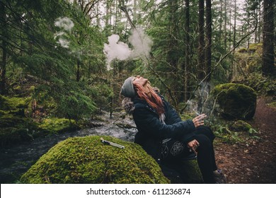 Blonde Woman Smoking Cannabis While Hiking In The Woods