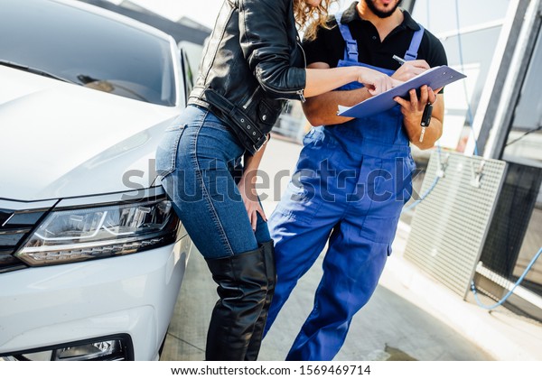 Blonde woman stands with a man who washes cars\
at the self-service, close up\
hpoto.