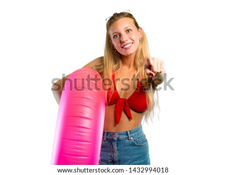 Blonde woman in summer vacation pointing to the front on isolated white background