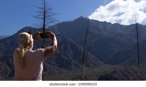 Blonde Woman Taking A Picture In A Beautiful Scenery.