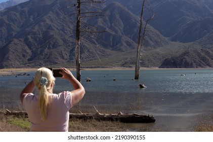 Blonde Woman Taking A Picture In A Beautiful Scenery.