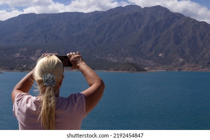 Blonde Woman Taking A Picture In A Beautiful Scenery.