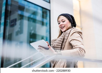 Blonde woman using a digital tablet outdoor