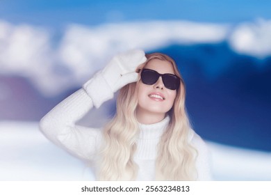 Blonde woman wearing warm mittens, sunglasses and jumper, winter snow nature background with copyspace fashion and lifestyle idea - Powered by Shutterstock