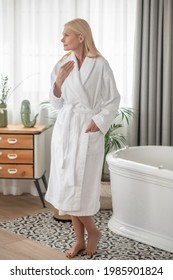 Blonde Woman In A White Bath Robe Looking Contented