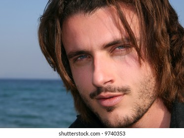 Blonde young man with blue eyes by the sea