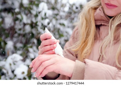 Blonde Young Woman Applying Cream On Skin Hands In Winter Season. Dry And Rough Skin Protection Treatment Outdoor