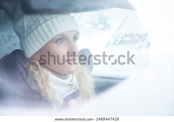 blonde\
young woman drives  in her  car in\
wintertime