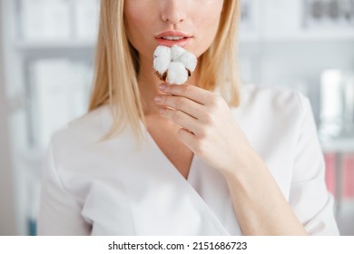 Blonde Young Woman Holding Cotton Plant Near Lips