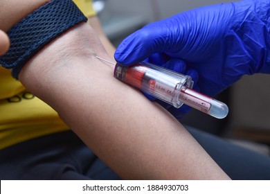 Blood collection using venipuncture technique in arm pit using safety gloves for covid19 test in Mumbai, India on December20-2020