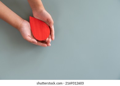 Blood Donation Or Medical Surgery Concept. Human Holding Small Piece Of Paper Blood Sign And A Red Heart Shape. Give Blood Save Lives.