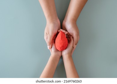 Blood Donation Or Medical Surgery Concept. Human Holding Small Piece Of Paper Blood Sign And A Red Heart Shape. Give Blood Save Lives.