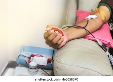 Blood Donor At Donation With Red Bouncy Ball Holding In Hand.