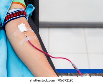 Blood Donor At Donation, Transfusion. Left Arm Of Asian Man Receiving Blood With Copy Space Background. Healthcare And Charity. Concept For World Blood Donor Day - Selective Focus.