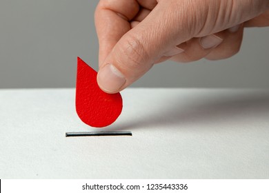 Blood Donor. Man Puts Drop Of Blood In The Piggy Bank As Donation. Concept Donate Blood Save Life