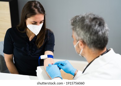 Blood Draw By Doctor In Laboratory In Face Mask