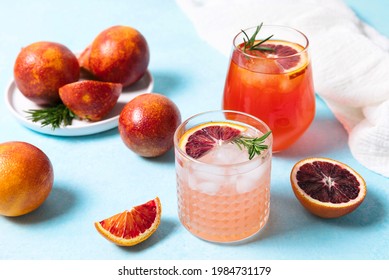 Blood Orange Cocktails With Fresh Fruits On Blue Table Background. Summer Cocktails, Lemonade, Refreshing Drinks, Low Alcohol Mocktail, Party Concept