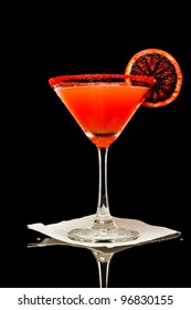 Blood Orange Color Martini Isolated On A Black Background With Red Sugar Rim