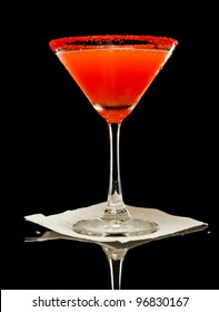 Blood Orange Color Martini Isolated On A Black Background With Red Sugar Rim