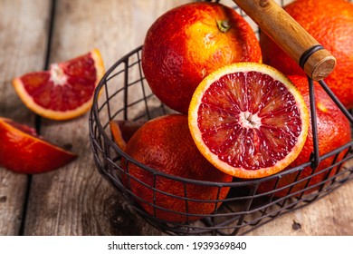 Blood oranges in a metal basket on a wood background. Top view. Flat lay.