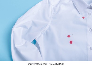 Blood Stain On Clothes. Isolated On Blue Background. Top View. High Quality Photo