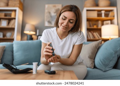 Blood sugar testing at home. Checking Blood Sugar Level At Home. Diabetic Checking Blood Sugar Levels. Woman checking blood sugar level by glucometer and test stripe at home