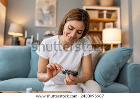 Blood sugar testing at home. Checking Blood Sugar Level At Home. Diabetic Checking Blood Sugar Levels. Woman checking blood sugar level by glucometer and test stripe at home