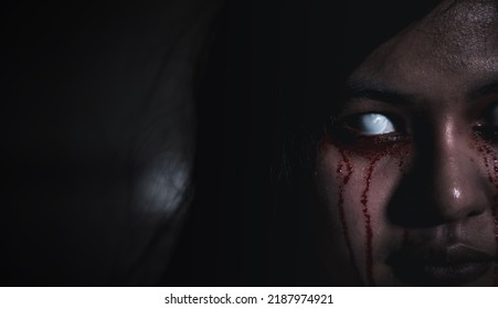 Bloody Halloween Makeup. Asian Woman With Blood Eye She Death And Scary With Blood Tear On Face, Close Up Of Horror Bloodthirsty Ghost Female With Fade Drop Out From Eyes, Happy Halloween Day Concept