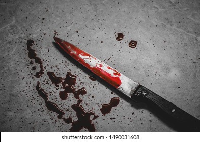 Bloody knife lies on the creepy messy background. Concept of a domestic killings and horror movies
