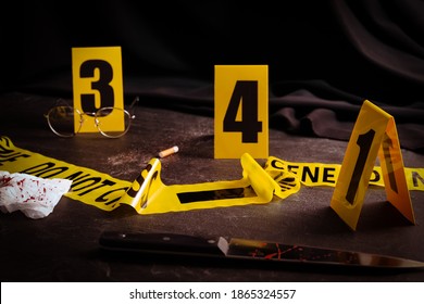 Bloody Knife, Tape And Markers On Black Slate Table. Crime Scene