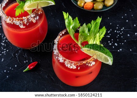 Bloody Mary cocktail close-up. Tomato juice and alcohol mix, garnished with lime and celery