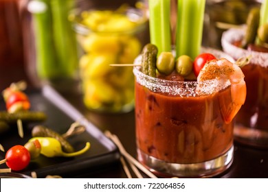 Bloody mary cocktail garnished with celery sticks and olives.