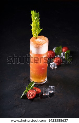 Bloody Mary Cocktail in glass with garnishes. Tomato Bloody Mary spicy drink on black background with copy space.