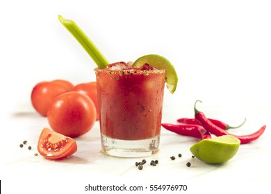 Bloody Mary cocktail with red hot chili peppers, slices of lime, celery sticks, a piece of tomato and copyspace - Powered by Shutterstock