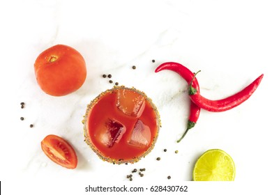 Bloody Mary cocktail, shot from above on a white marble texture, with red hot chili peppers, slices of lime, tomatoes, and copy space - Powered by Shutterstock