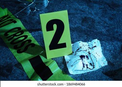 Bloody Napkin, Tape And Crime Scene Marker On Stone Table At Night