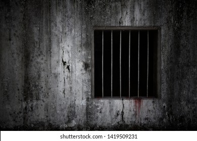 Bloody scary on the window with rusty bars on old grungy prison cell wall, concept of horror and Halloween