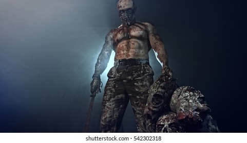 Bloody Zombie Killer Standing With A Machete And Severed Heads In The Dark And Smoke. Horror.